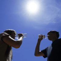 Tony Berastegui Jr., right, and his sister Giselle Berastegui drink water, Monday, July 17, 2023, in Phoenix. Ross D. Franklin / AP